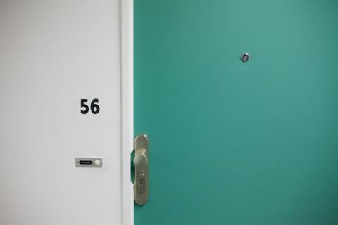 Photo of a green apartment door and doorknob with a lock